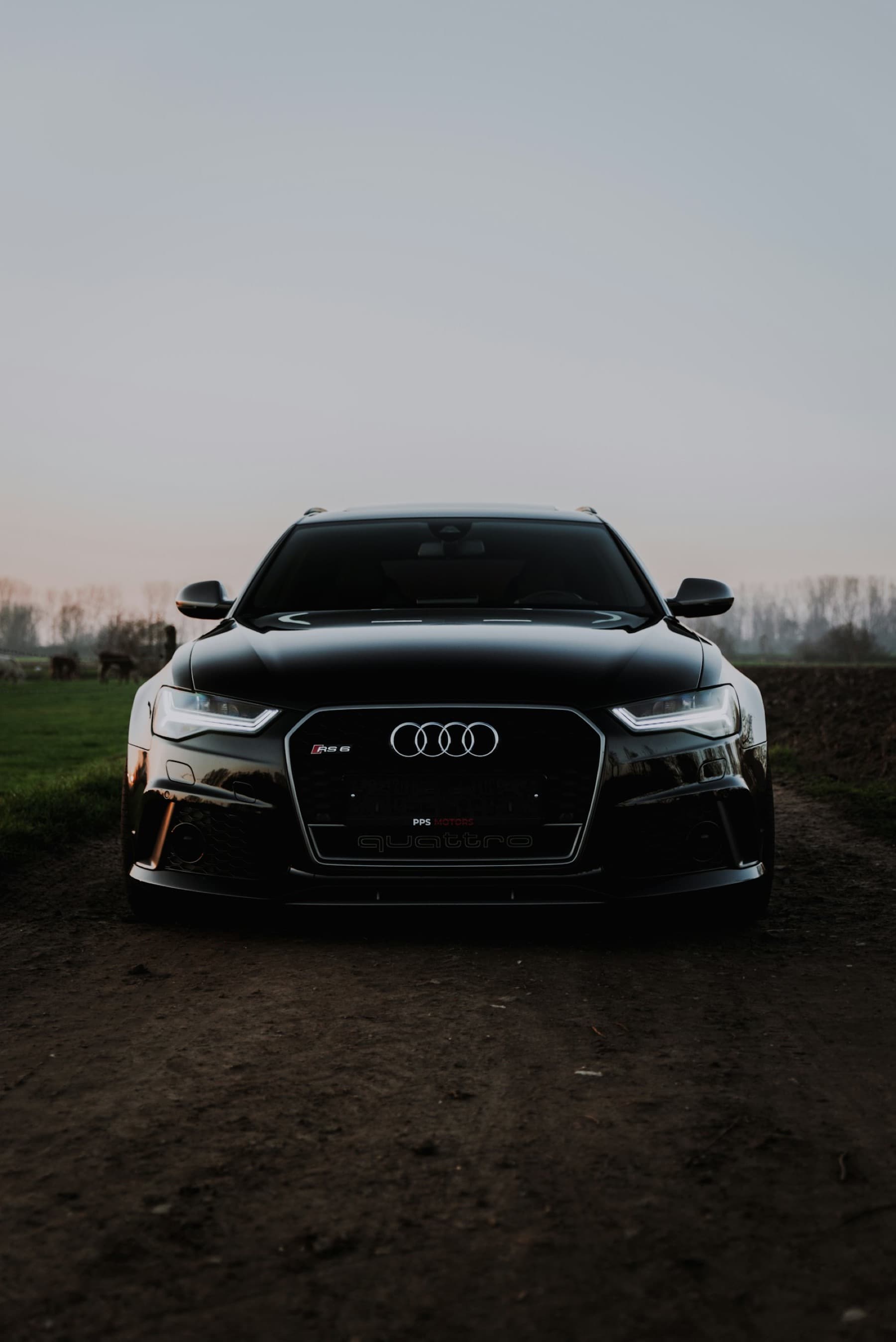 Automotive silhouette at blue hour — used as backdrop, heavily desaturated and darkened.