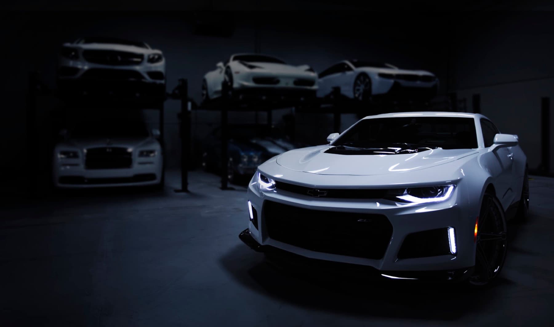 Atmospheric collector garage interior — used as backdrop, heavily desaturated and darkened.